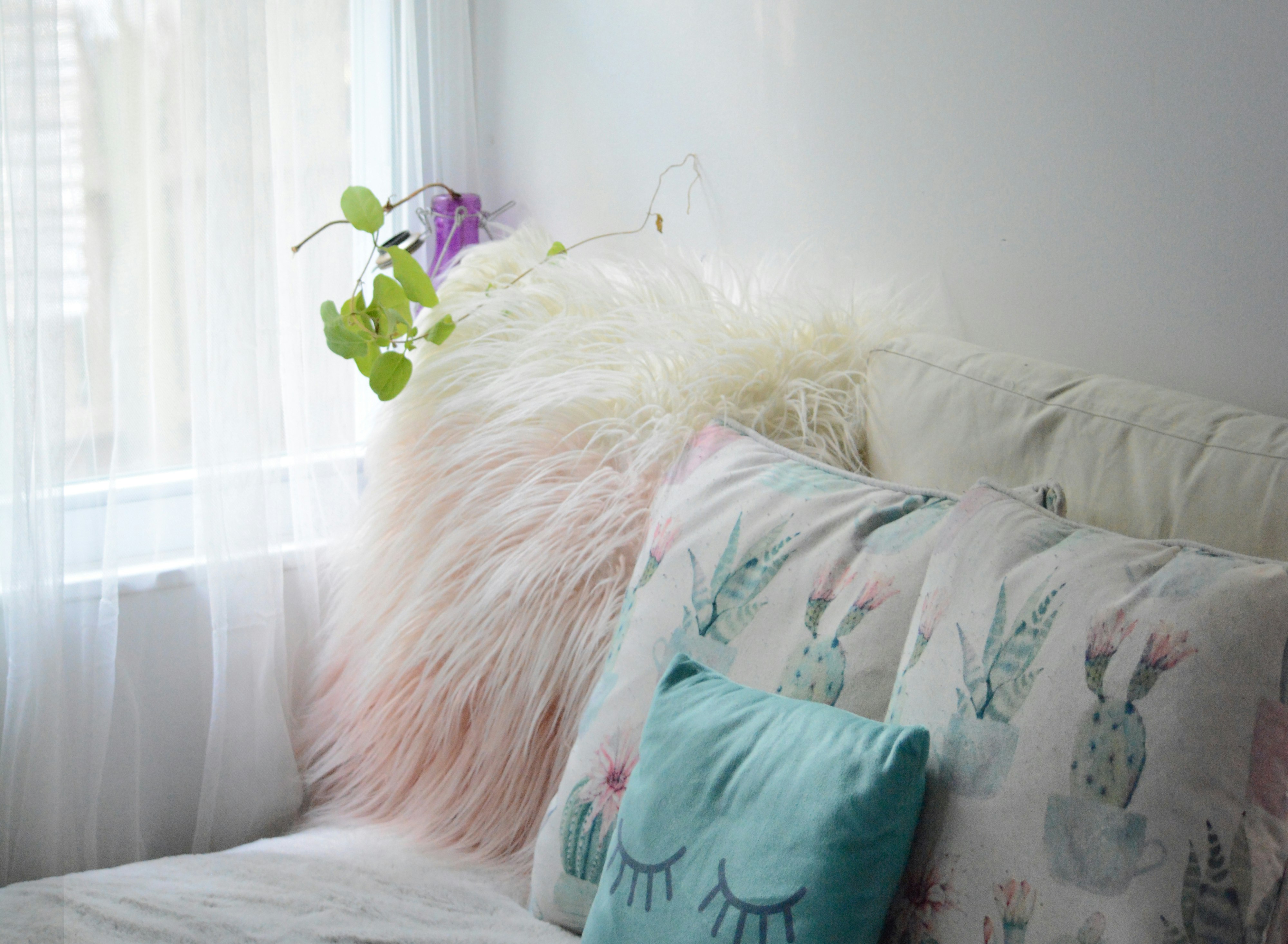 green throw pillow on white couch